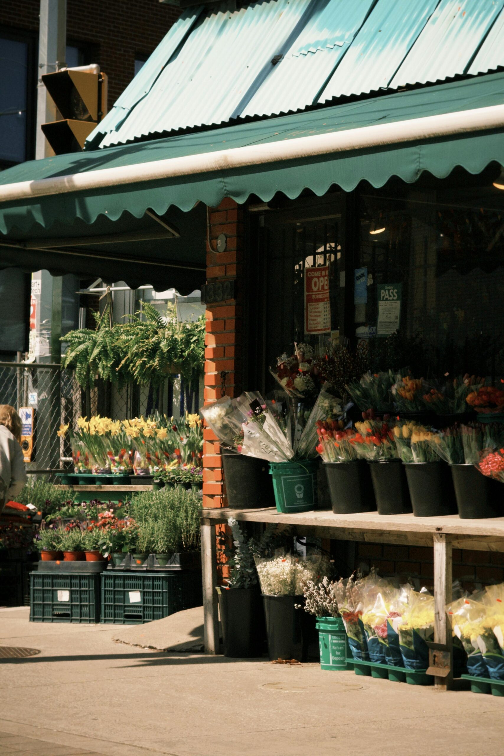 Outdoor flower shop on a sunny day in Toronto, Canada, showcasing vibrant blooms and greenery.